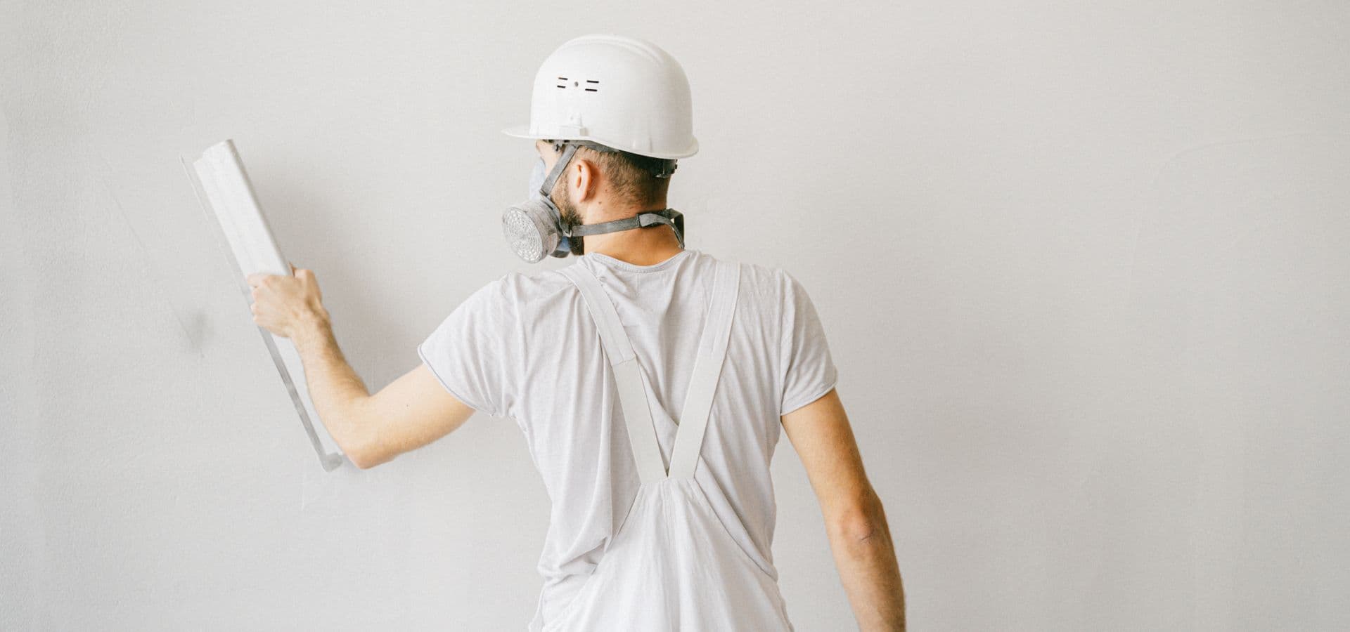 Professional plasterer applying plaster to a wall